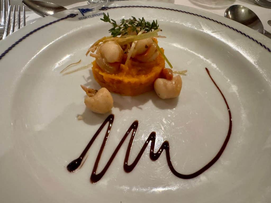 A tomato tartlet topped with small scallops.