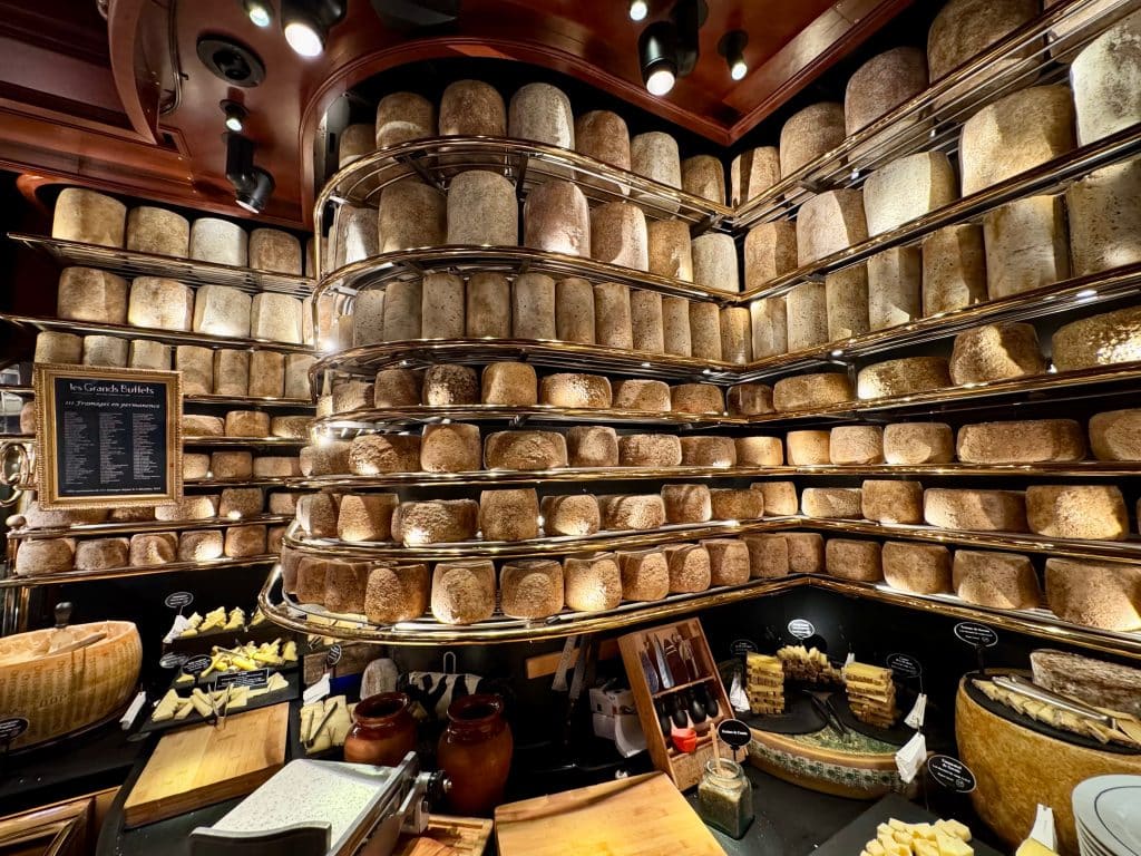 A display buffet with what looks like hundreds of wheels of cheese.