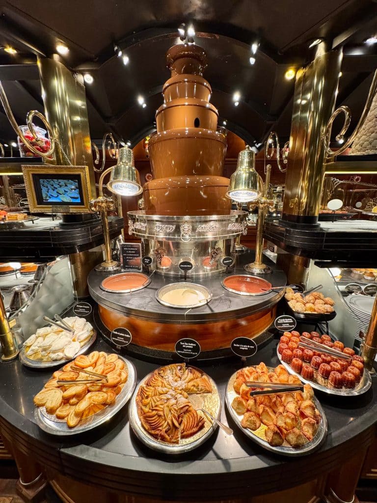 A chocolate fountain surrounded by pastries.