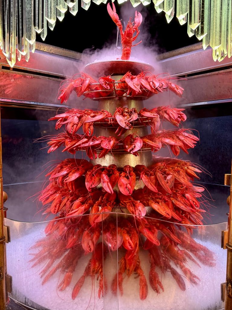 A tall, round lobster tower with dry ice making it surrounded with mist.