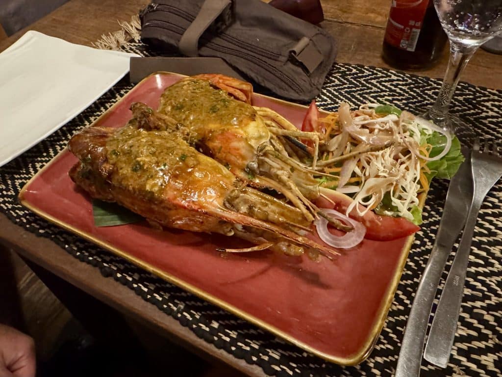 Two lobsters covered in a peppery sauce.