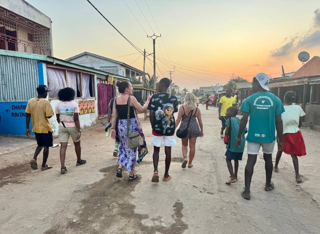 A group of travelers and local kids walking down a street in Madagascar.