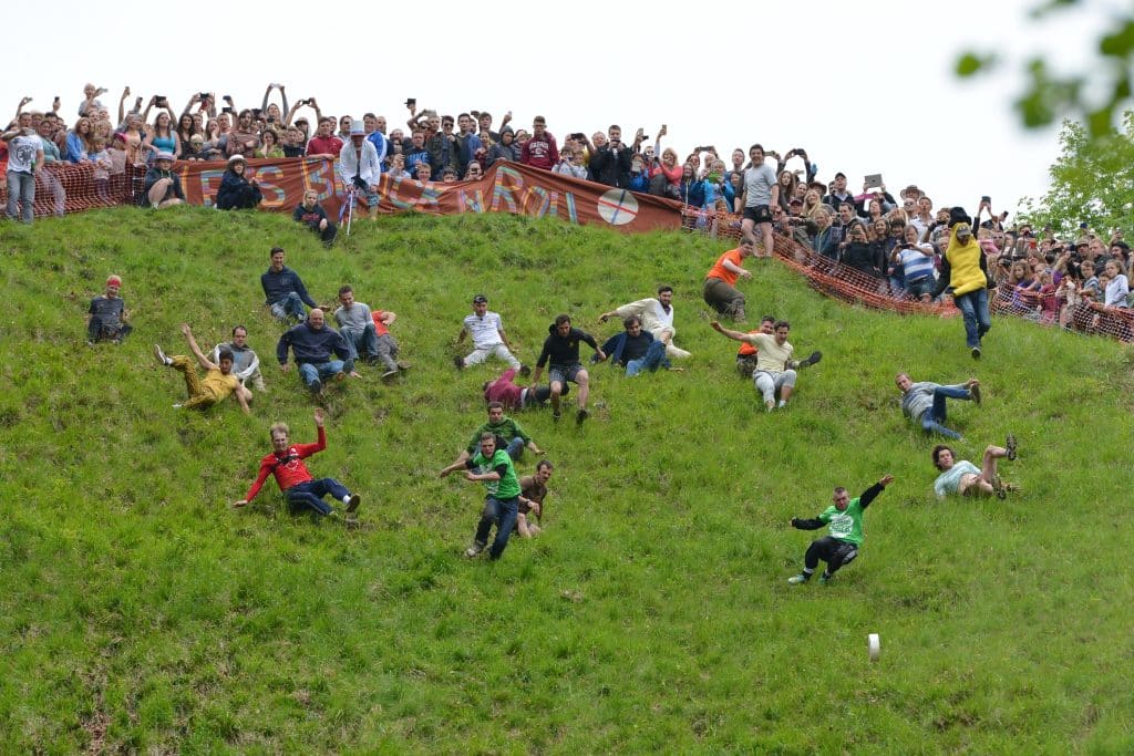 Men running down a steep hill and falling over themselves at Cooper's Hill.