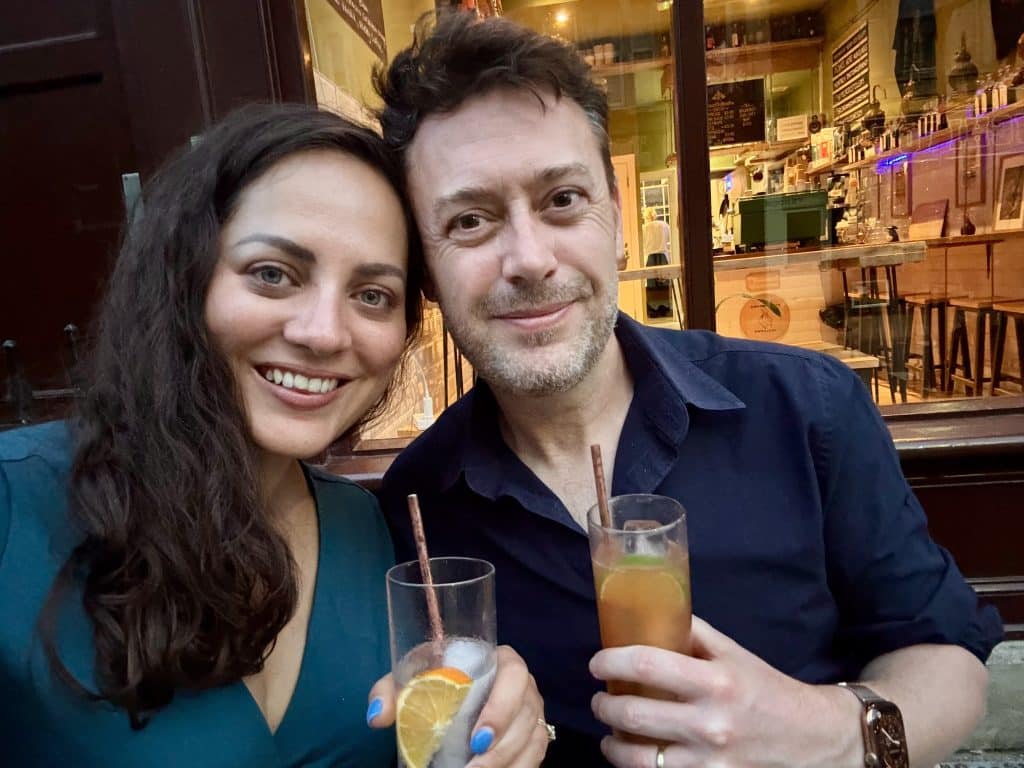 Kate dan Charlie mengambil selfie tersenyum sambil memegang koktail.