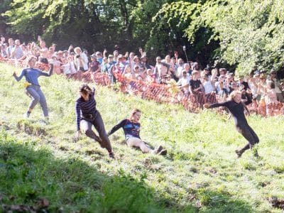 Four women running and sliding down the hill