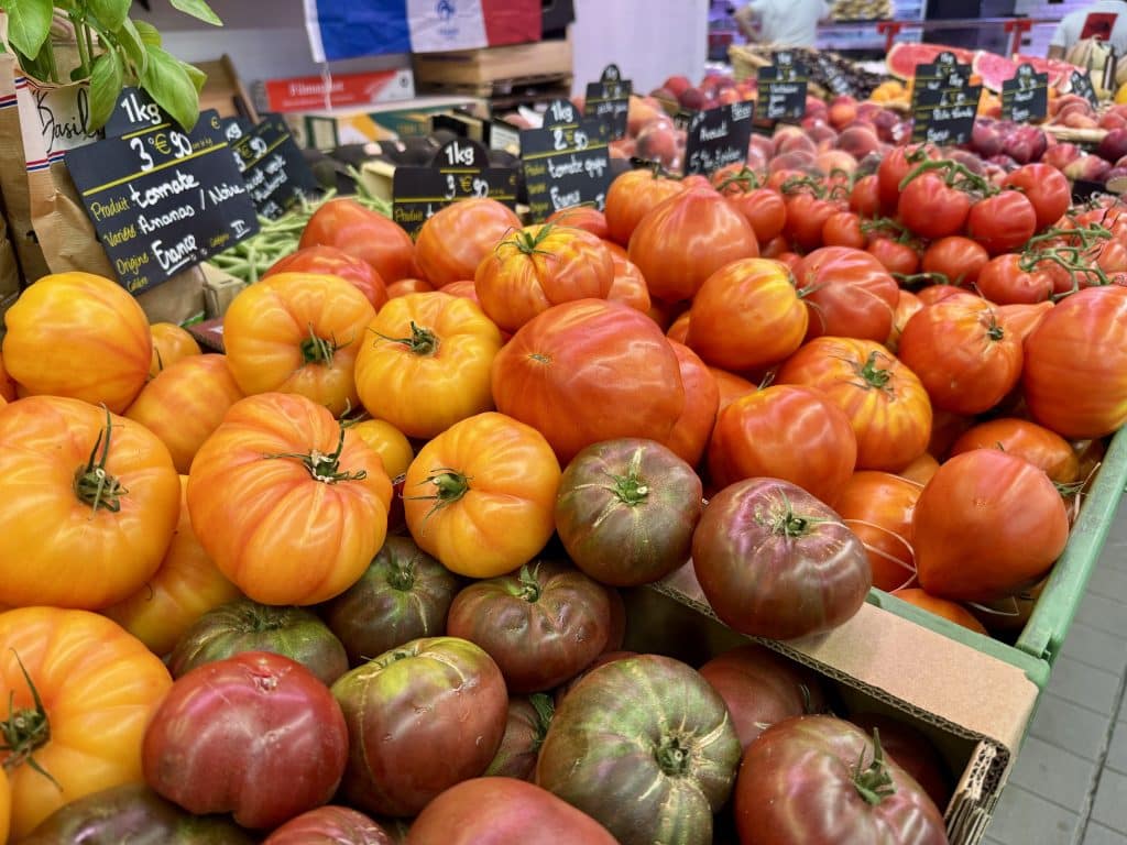 A display of tomatoes in yellow, red, brown, and green.