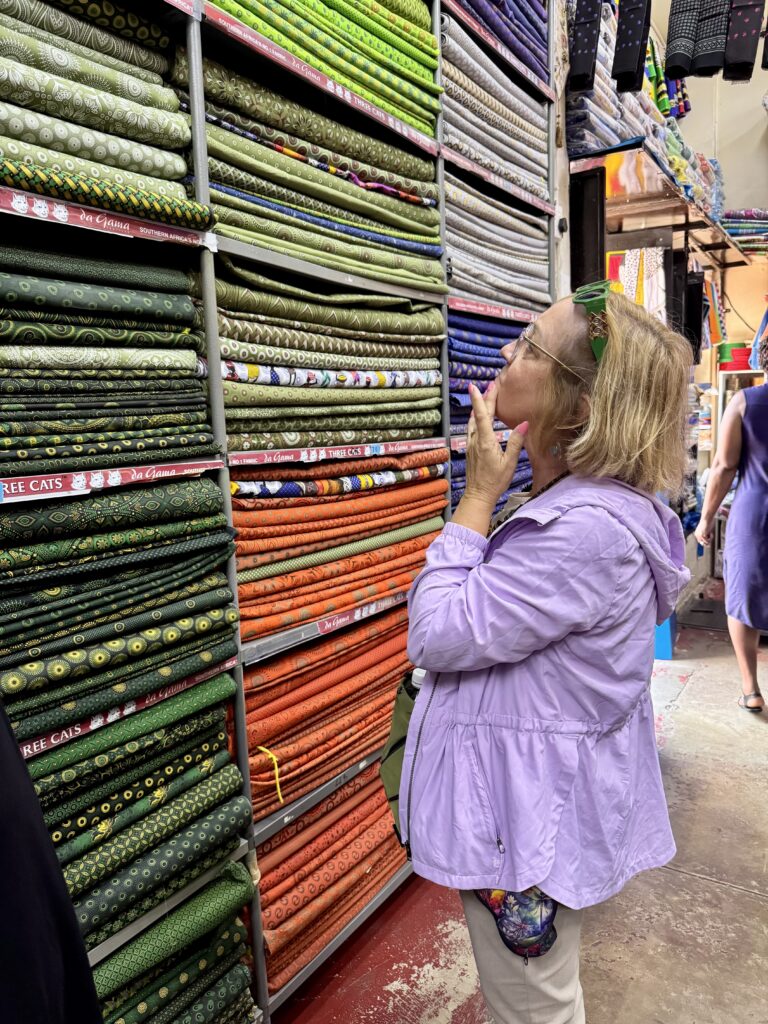 Kate's mom looking at shelves covered with hundreds of African fabrics.